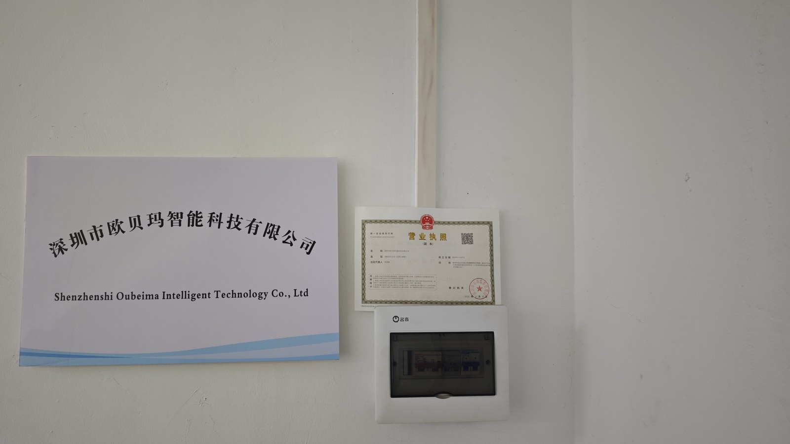 公司名称标牌与营业执照悬挂于办公场所的实景照片